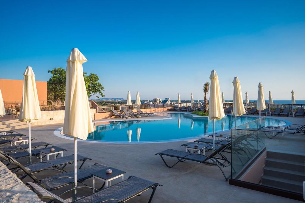 basen z krzesłami i parasolami w obiekcie Hotel Pyriá w mieście Hersonissos