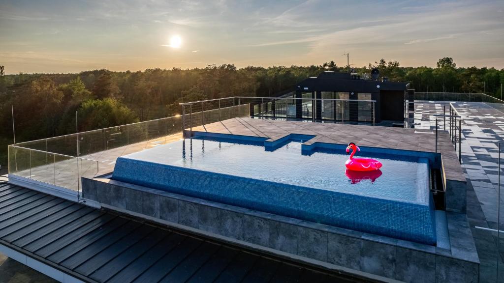 a pool on top of a building with a person in the water at Sea&Lake, Sun & Snow in Mielno