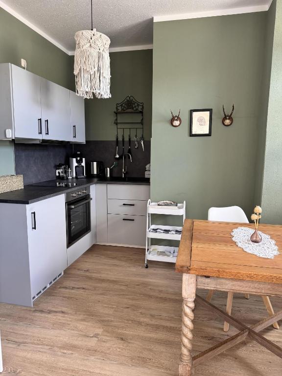 a kitchen with white cabinets and a wooden table at Ferienwohnung Erzgebirgsnest in Annaberg-Buchholz