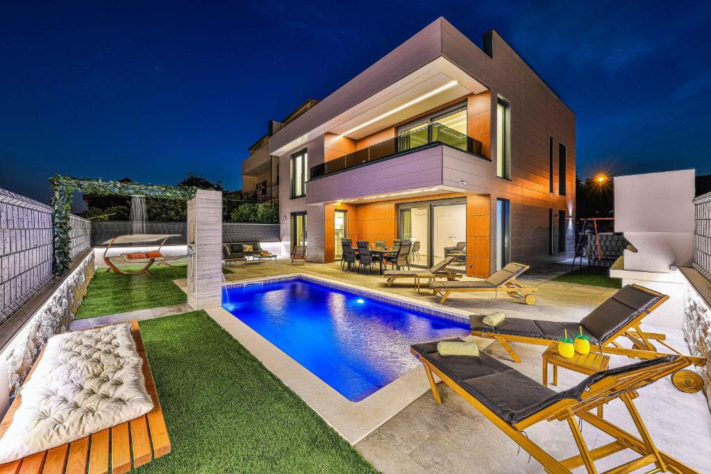 a house with a swimming pool in the yard at Villa Pavlina in Kaštela