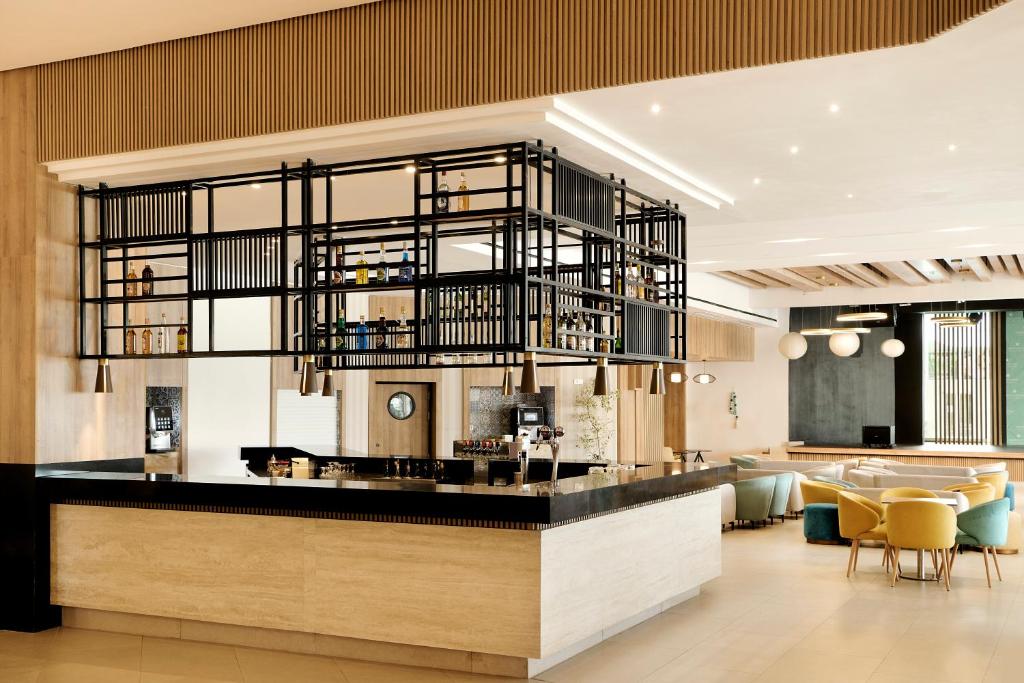a lobby with a bar and a dining area at Iberostar Waves Mehari Djerba in Taguermess