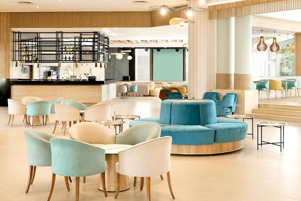 a waiting room with blue chairs and tables at Iberostar Waves Mehari Djerba in Taguermess