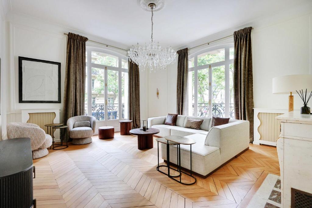 d'un salon avec un canapé blanc et un lustre. dans l'établissement Sublime apartment - 2BR-4P - Arc de Triomphe, à Paris