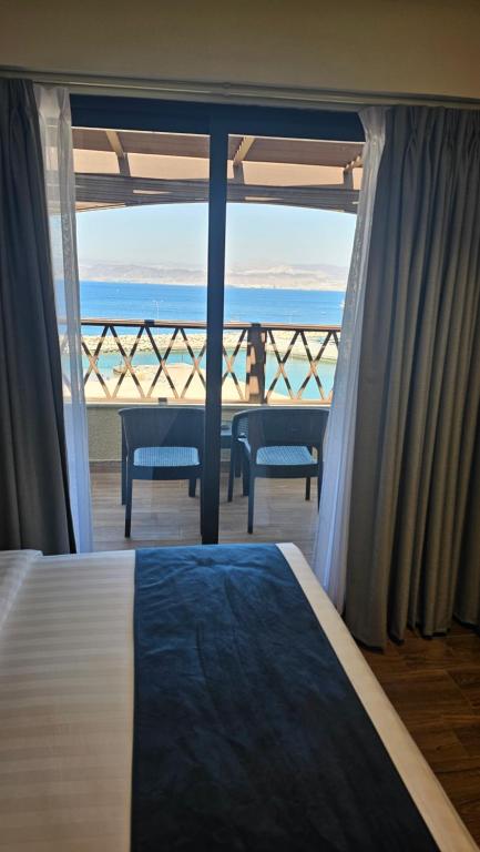 a bedroom with a bed and a view of the ocean at Saraya Abdeen Hotel in Aqaba