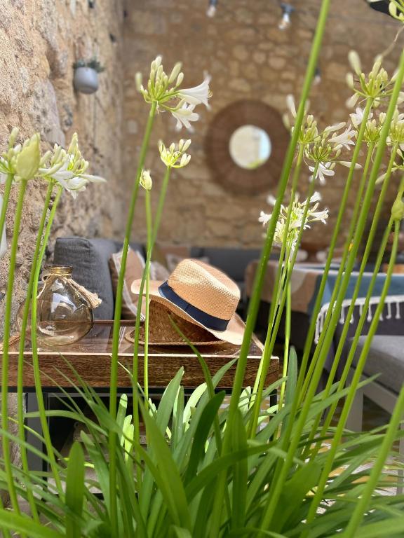 a hat sitting on top of a table with flowers at La Maison du Clocher in Saint-Émilion