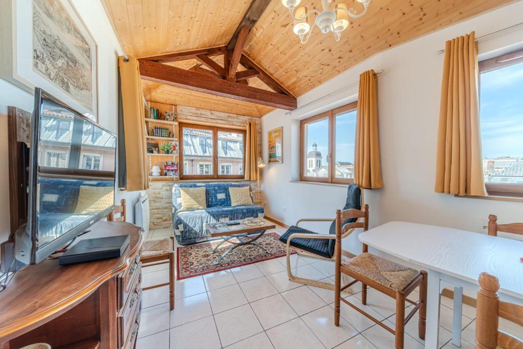 un salon avec un canapé et une télévision dans l'établissement Charming duplex with panoramic view of Cordeliers, à Lyon
