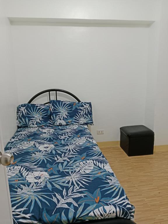 una camera con letto e lenzuola bianche e blu di Mactan Oasis gardens condominium a Lapu Lapu City