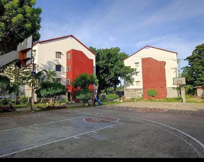 una strada vuota con due edifici rossi e bianchi di Mactan Oasis gardens condominium a Lapu Lapu City