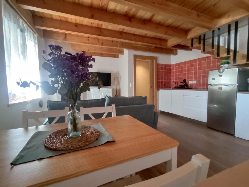 a kitchen and living room with a table with a vase of flowers at Casa Malba in Sevares