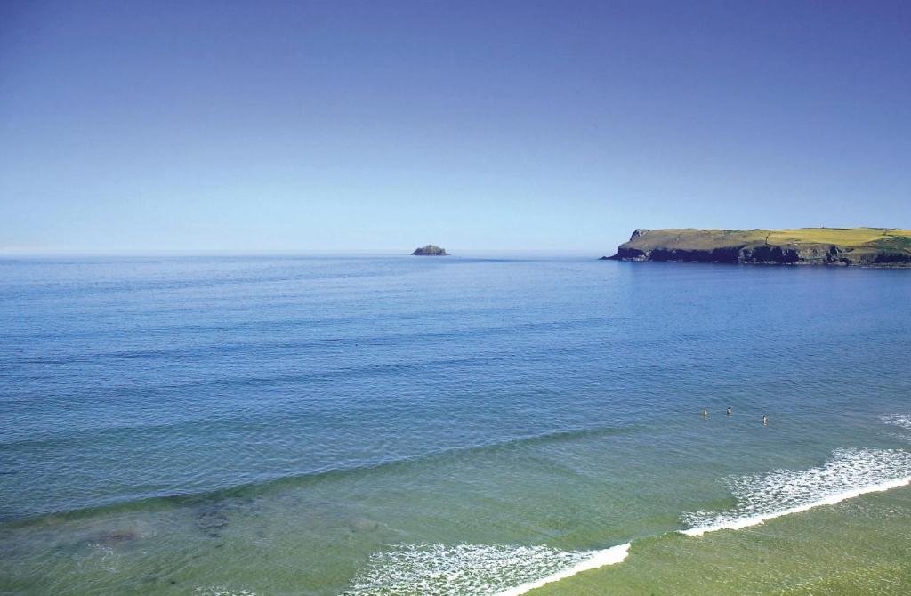 a body of water with a group of people in the water at St Moritz Hotel and Cowshed Spa in Polzeath