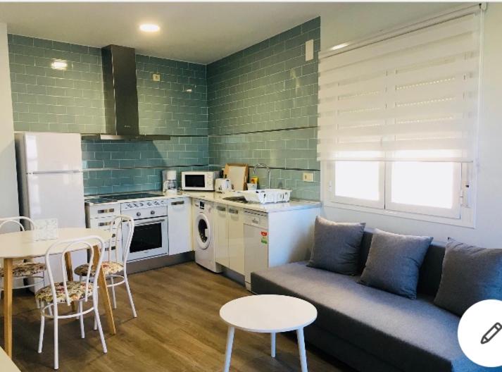 a living room with a couch and a table and a kitchen at Apartamento San Miguel Nº1 in Jarandilla de la Vera