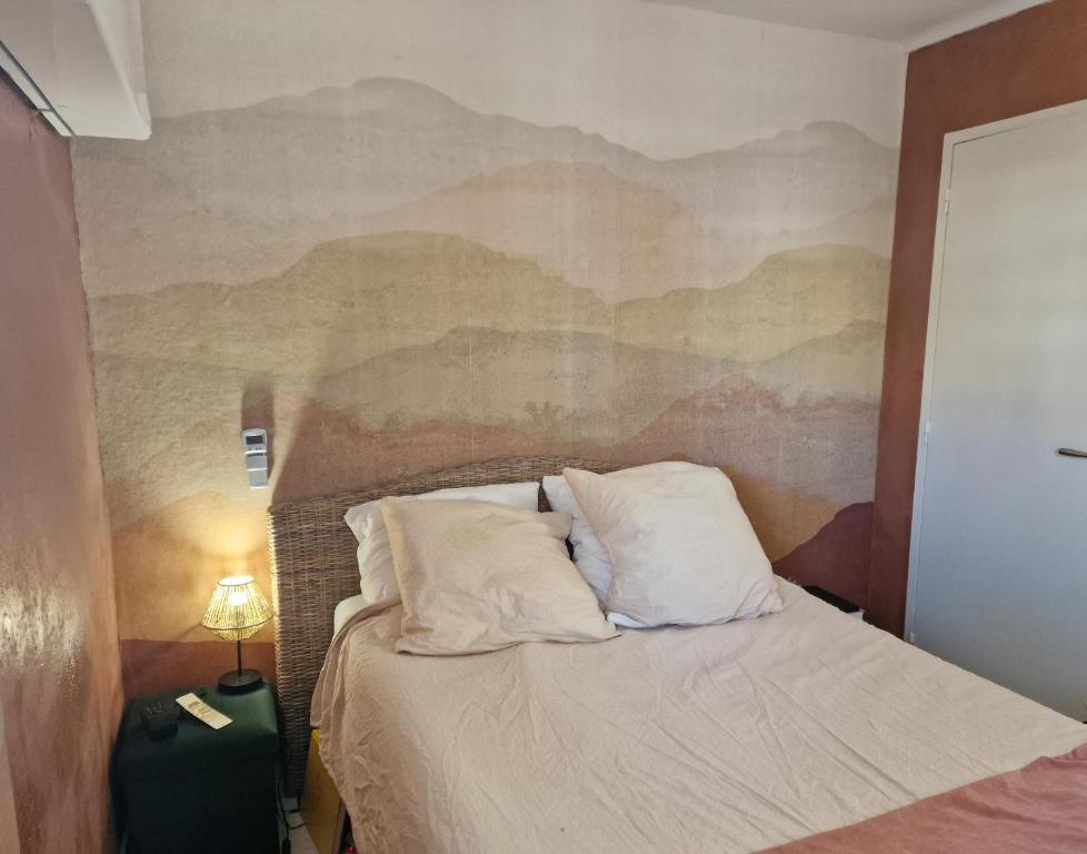 sypialnia z łóżkiem i obrazem na ścianie w obiekcie Appt T3 VUE MER w mieście Six-Fours-les-Plages