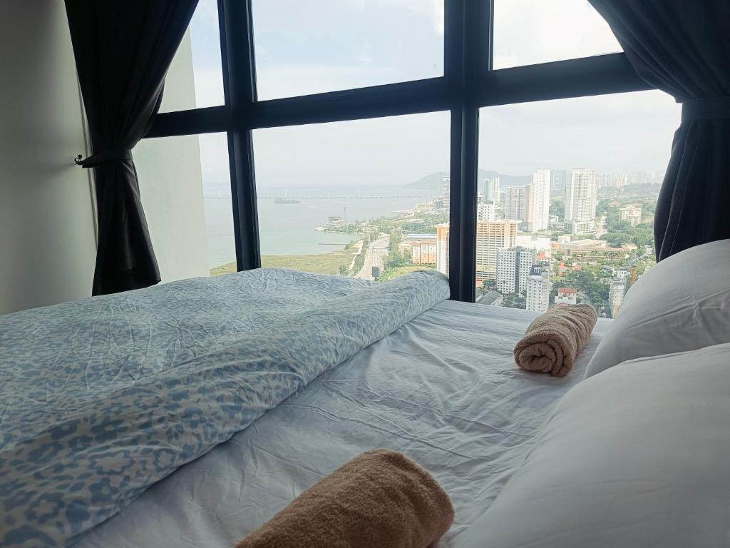 a bed in a room with a large window at World Class Apartment In Georgetown 3BR in Jelutong