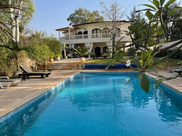 a large swimming pool in front of a house at Warang plage villa in Mbour