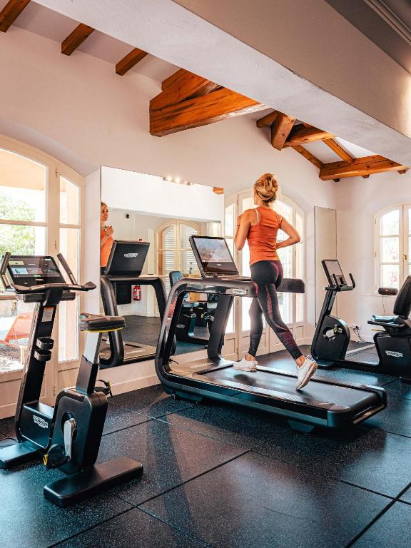 a woman running on a treadmill in a gym at Domaine de l'Astragale in Saint-Tropez