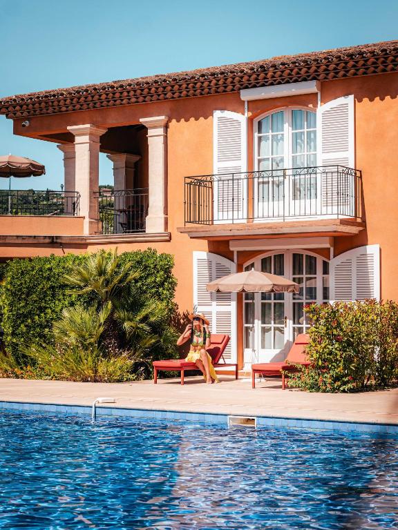 a man sitting on a bench in front of a house at Domaine de l'Astragale in Saint-Tropez