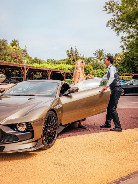 a man and a woman standing next to a car at Domaine de l'Astragale in Saint-Tropez