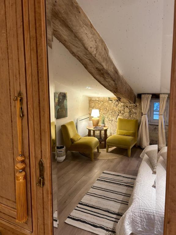 a room with a bed and two chairs and a table at La Maison du Clocher in Saint-Émilion