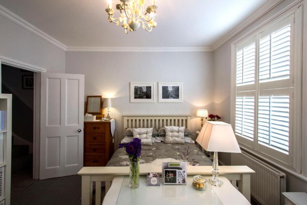 a bedroom with a bed and a table with a lamp at Windsor Road Retreat in Richmond