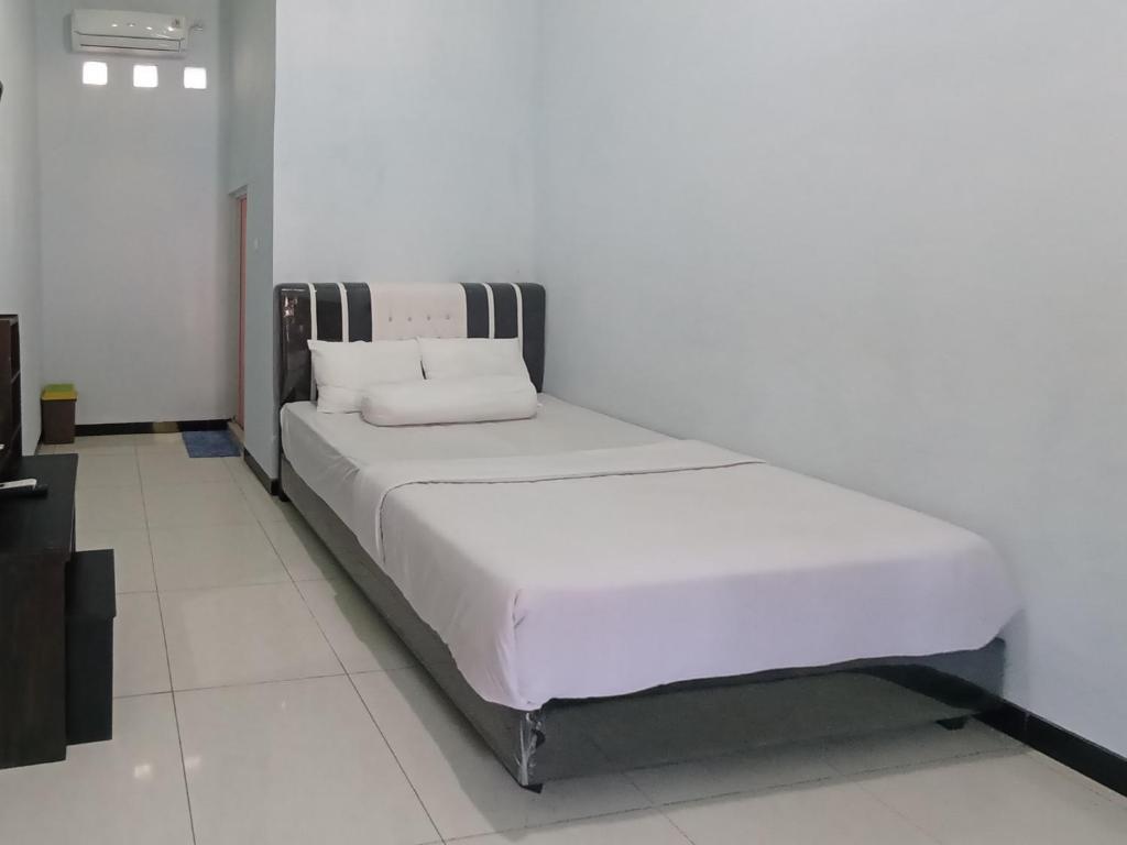 a white bed with two pillows on it in a room at Surya Abadi Homestay Syariah RedPartner in Kebumen