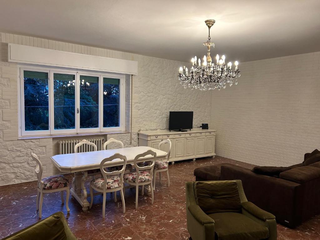 a living room with a table and chairs and a chandelier at La casa matta in Verucchio