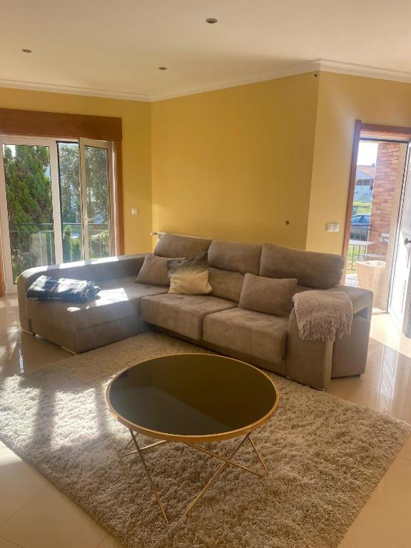 a living room with a couch and a coffee table at Welcoming house with terrace and garden in Barra de Mira in Areão