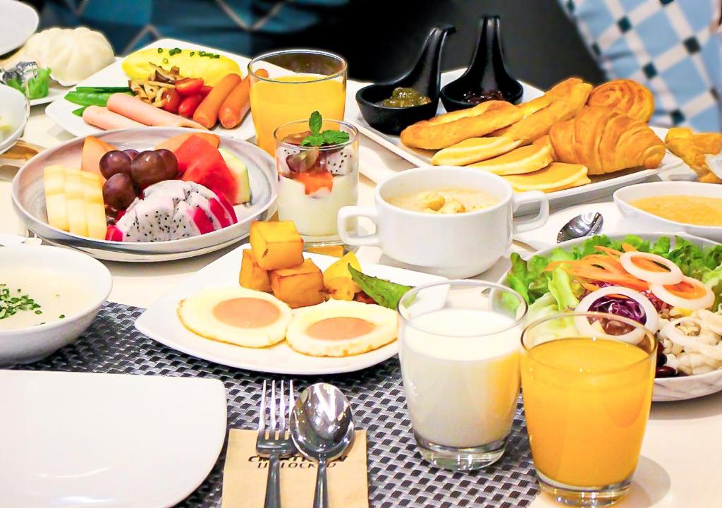 A generously styled breakfast spread with fruit, pastries, eggs, drinks, and salads.