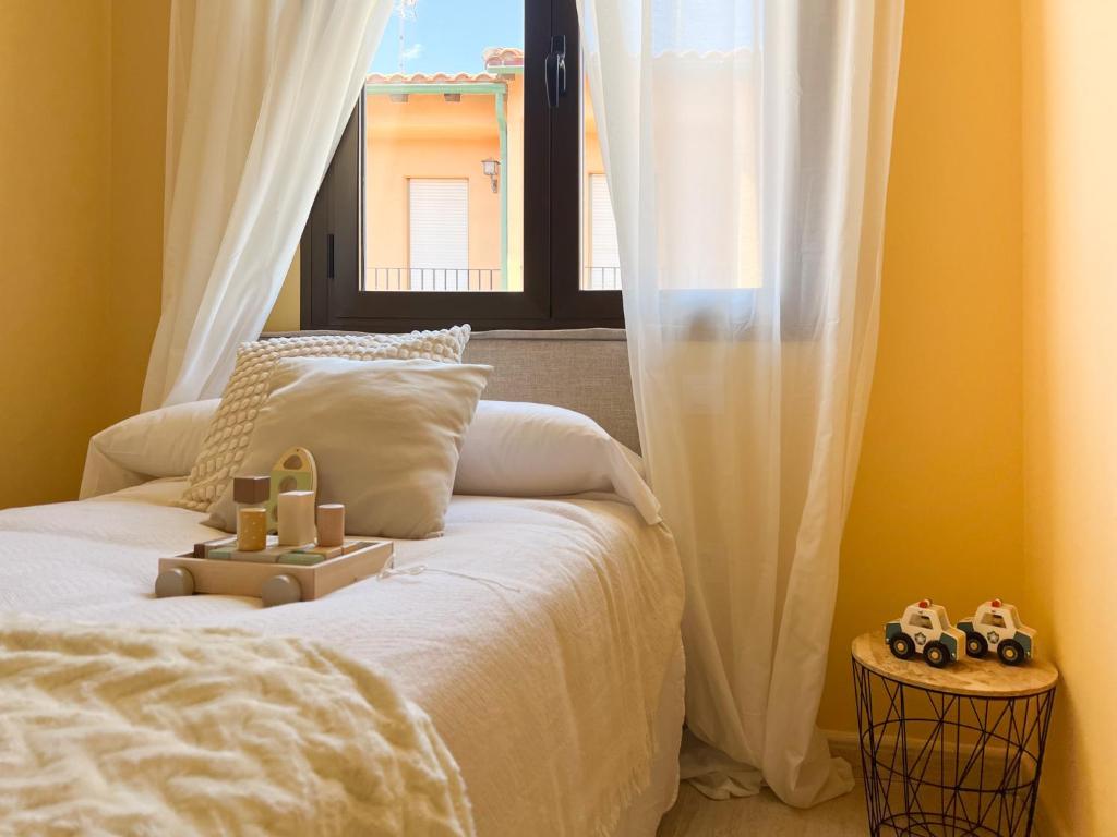 une chambre avec un lit avec des rideaux blancs et une fenêtre dans l'établissement VillaHomes, à Villanueva de la Vera