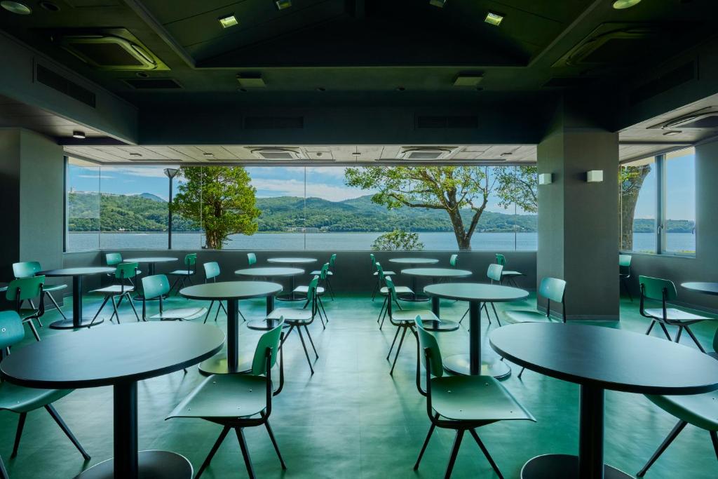 a room with tables and chairs and a large window at Mt Fuji View and Private Sauna Ryokan Shizuku in Yamanakako