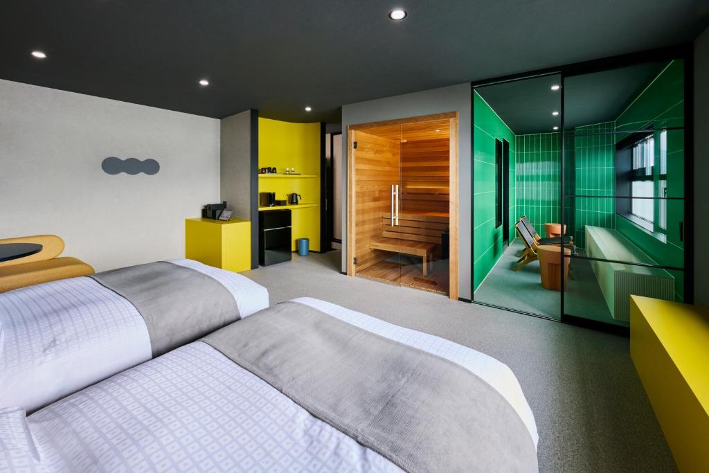 a bedroom with a large bed and a bathroom at Mt Fuji View and Private Sauna Ryokan Shizuku in Yamanakako