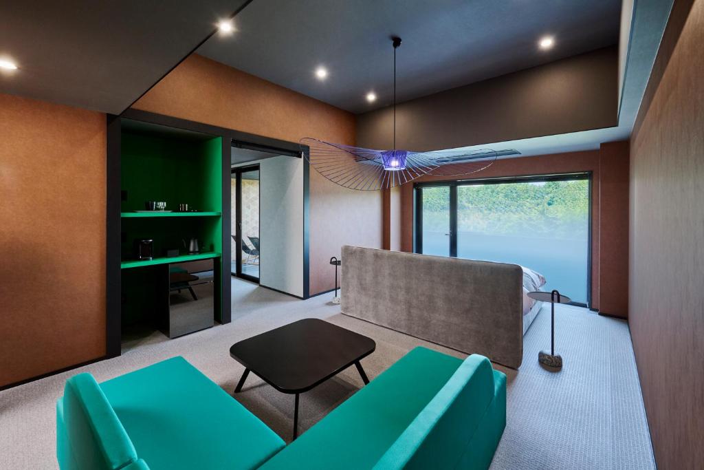 a living room with a couch and a table at Mt Fuji View and Private Sauna Ryokan Shizuku in Yamanakako