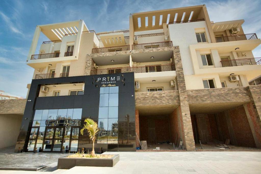 un grande edificio con una palma di fronte di Marina residence alamein a El Alamein