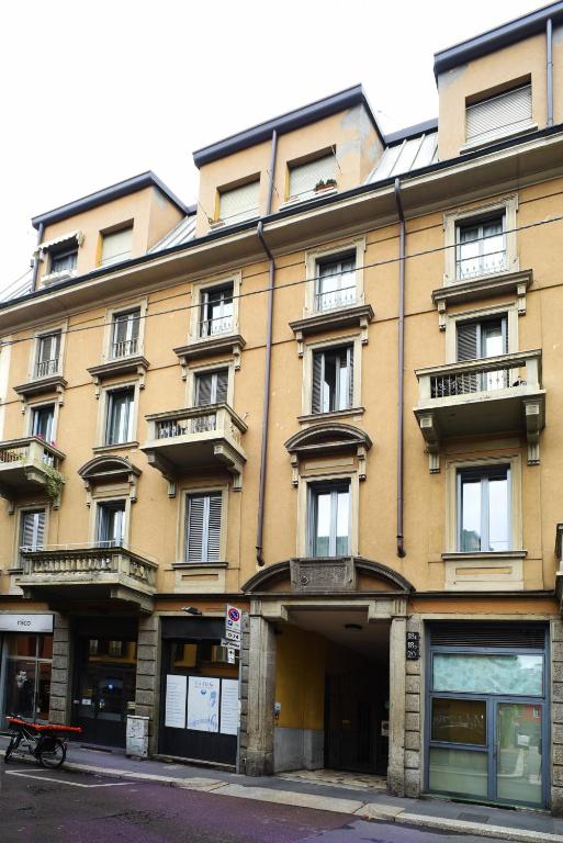 duży żółty budynek z balkonami na ulicy w obiekcie B&B Sant'Agostino w Mediolanie