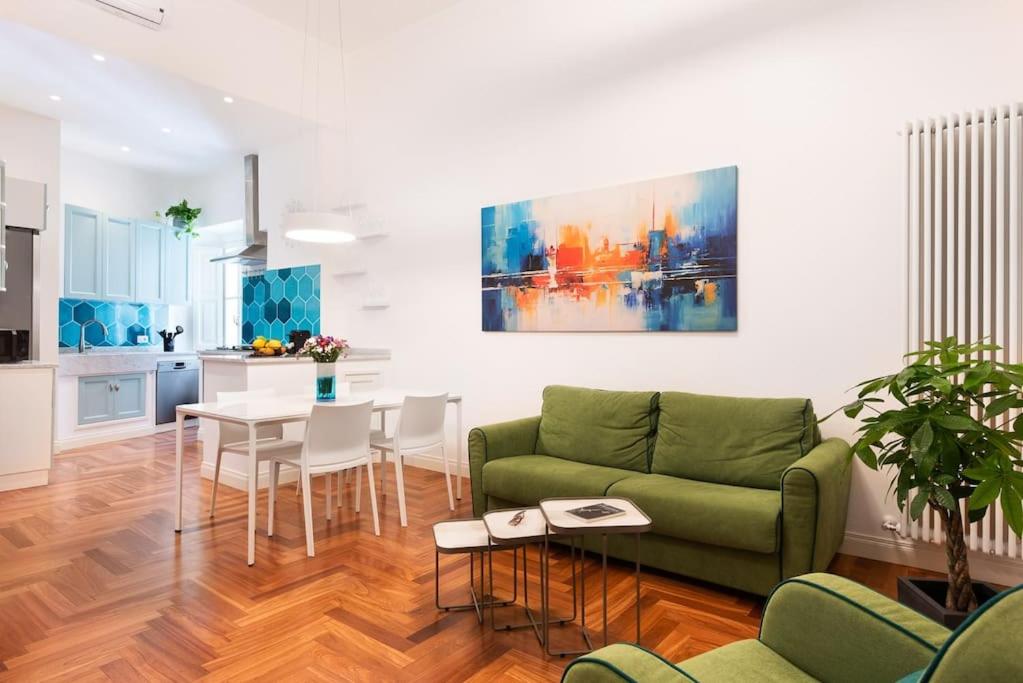 un soggiorno con un divano verde e un tavolo di Idyllia - Vatican Stylish Flat a Roma
