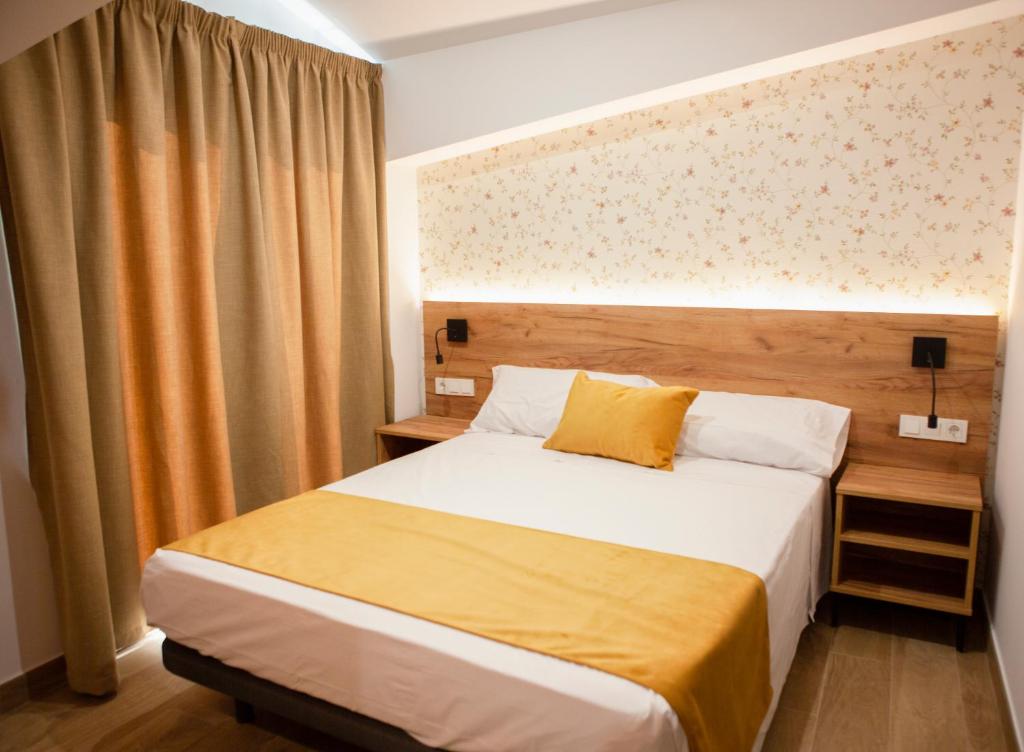 Un dormitorio con una cama grande con una manta amarilla. en PENSION RESTAURANTE ANGEL, en Huelma