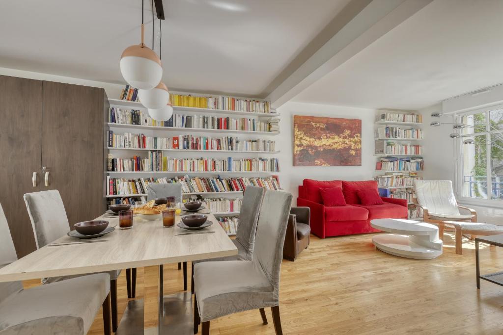 un salon avec une table et un canapé rouge dans l'établissement Superb Flat with Balcony - Near Notre-Dame - Paris 05, à Paris
