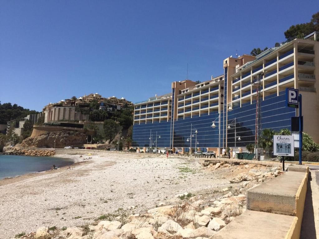 a large building on a beach next to the water at Apartment Bleakley in Altea