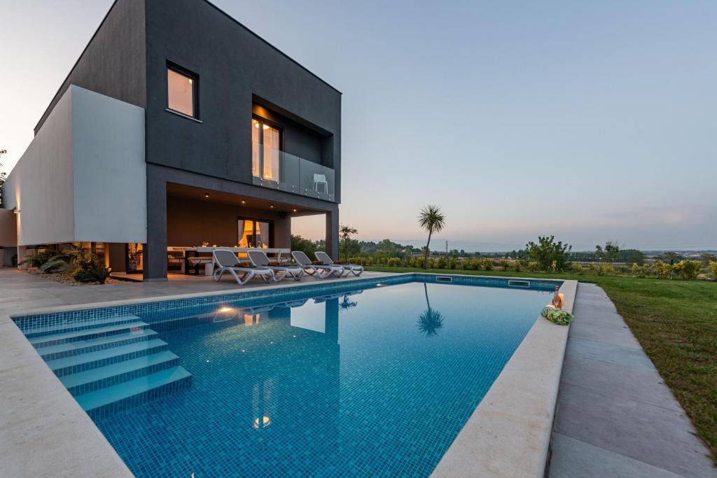 a house with a swimming pool in front of it at Villa Lux ZadarVillas in Donji Zemunik