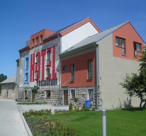 a large building with red and white at Hotel Mlyn in Zavar