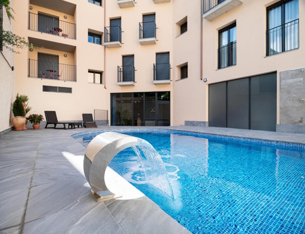a swimming pool in front of a building at Apartamentos Torre del Reloj in Jaca