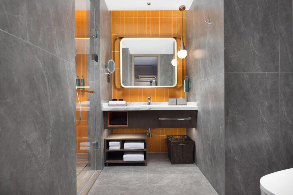 a bathroom with a sink and a mirror at Home2 Suite by Hilton Wuhan Economic Development Zone in Wuhan