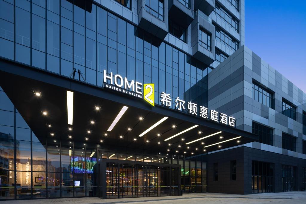 a building with a sign on the side of it at Home2 Suite by Hilton Wuhan Economic Development Zone in Wuhan