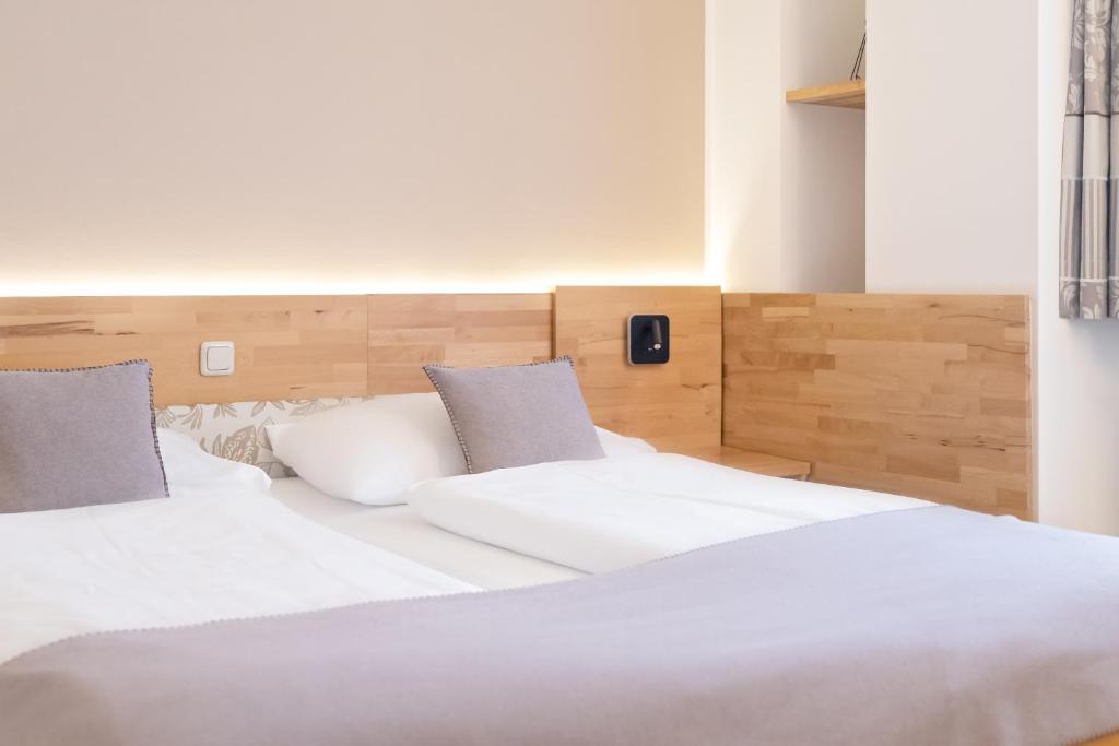Un pat sau paturi într-o cameră la FrühstücksHotel Scharinger