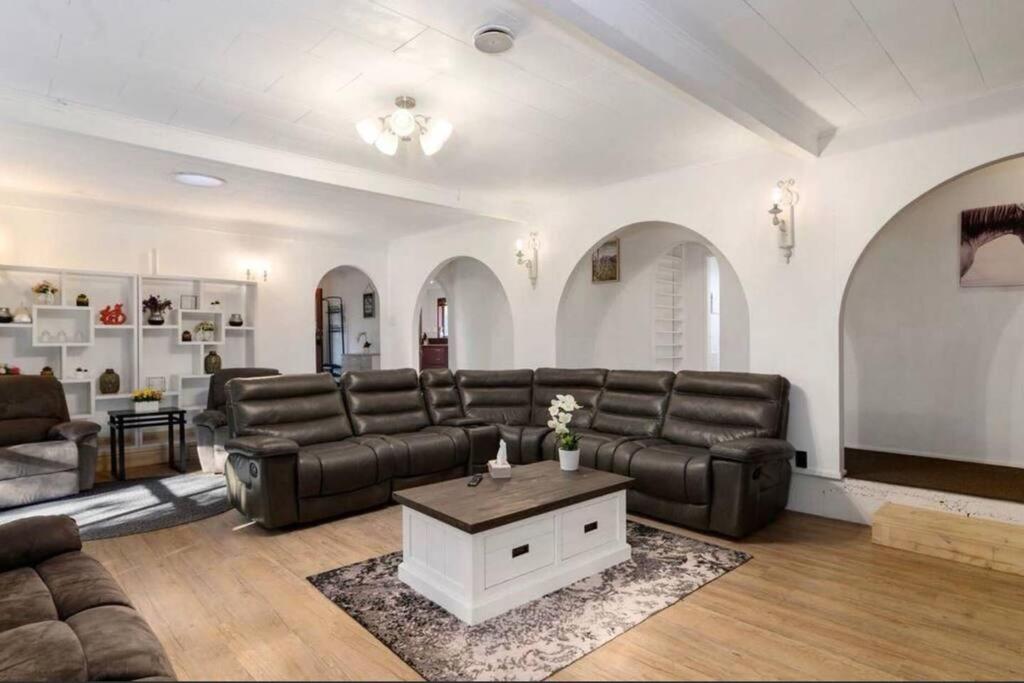a living room with a leather couch and a table at Hopoe City Villa in Rotorua