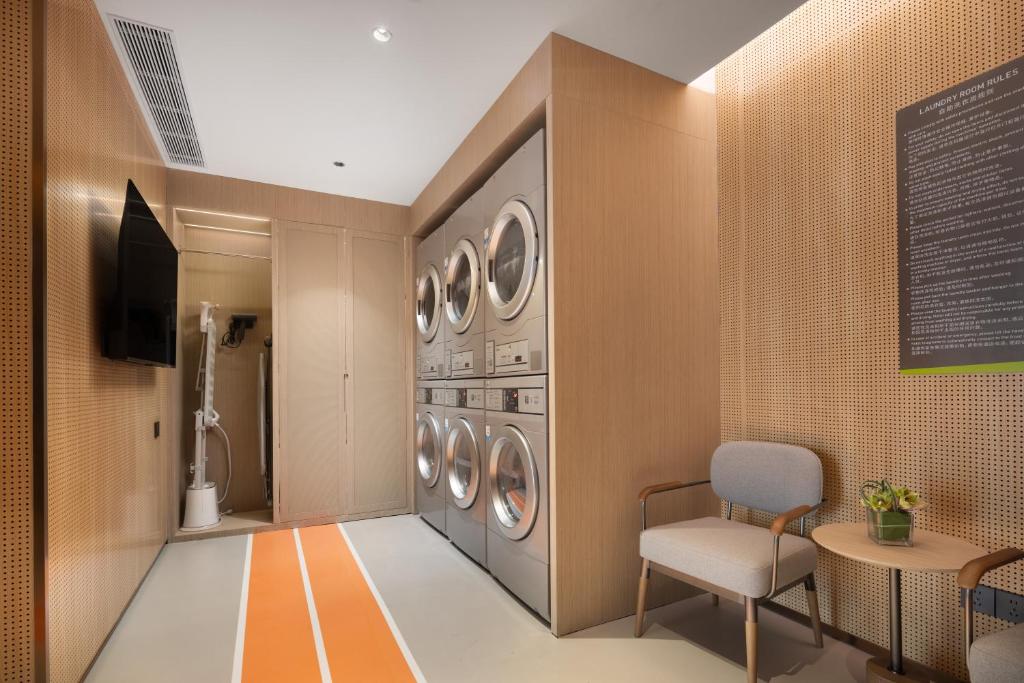 a laundry room with a row of washers and dryers at Home2 Suite by Hilton Wuhan Economic Development Zone in Wuhan