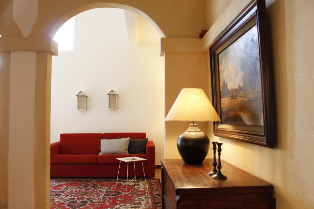 un soggiorno con divano rosso e lampada di Casa Vacanze Le Esperidi a Matera