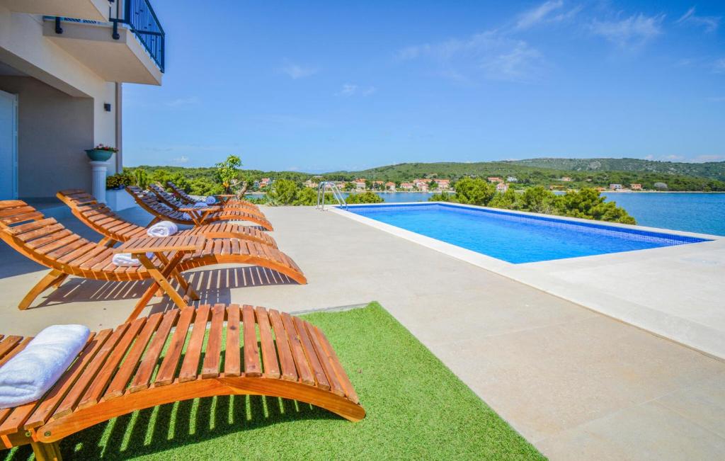 un patio con sedie e una piscina di Gorgeous Home In Veli Rat With Wifi a Veli Rat
