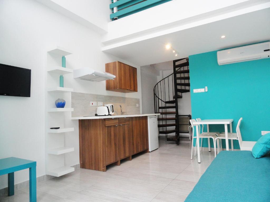een keuken en een woonkamer met een tafel en stoelen bij Rainbow Apartments in Ayia Napa