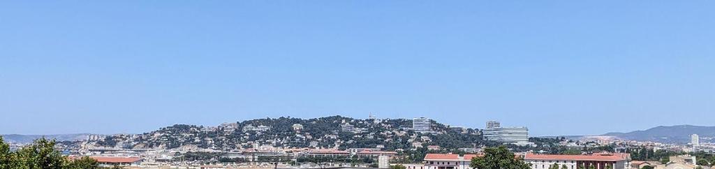 - une vue sur une ville avec des bâtiments sur une colline dans l'établissement Chambre vue mer, à Marseille