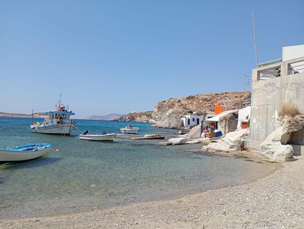 a group of boats on the water near a beach at Kimolos Seafront in Kimolos